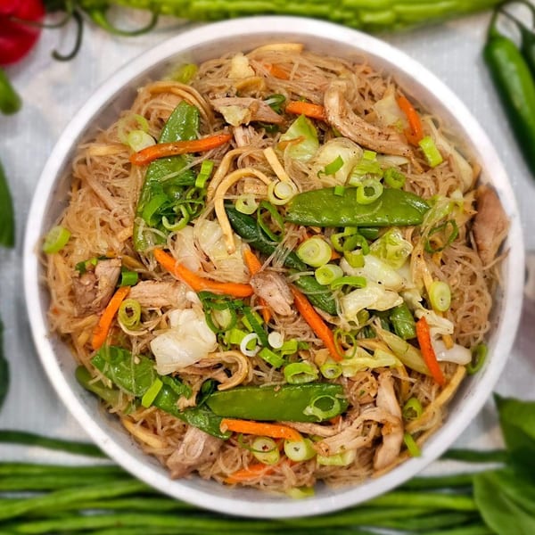 A close-up of Kusinera Filipino Cuisine's Pancit Bihon, featuring thin noodles, chicken, and vegetables.