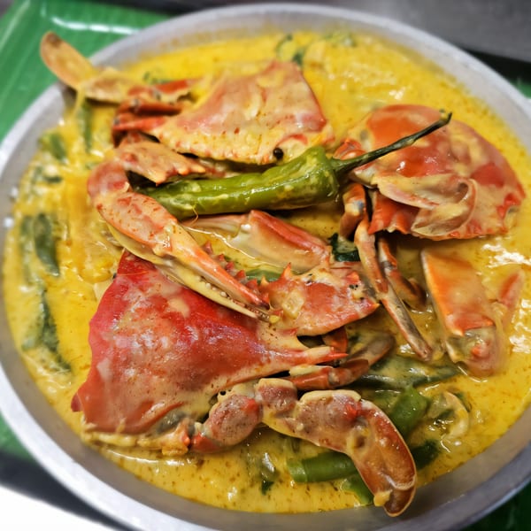 Filipino Ginataang Alimango, crabs in a rich yellow coconut milk sauce with green beans and chili.